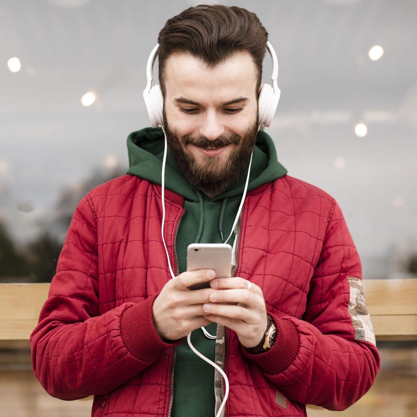 Smiley guy with headphone and looking smartphone screen
